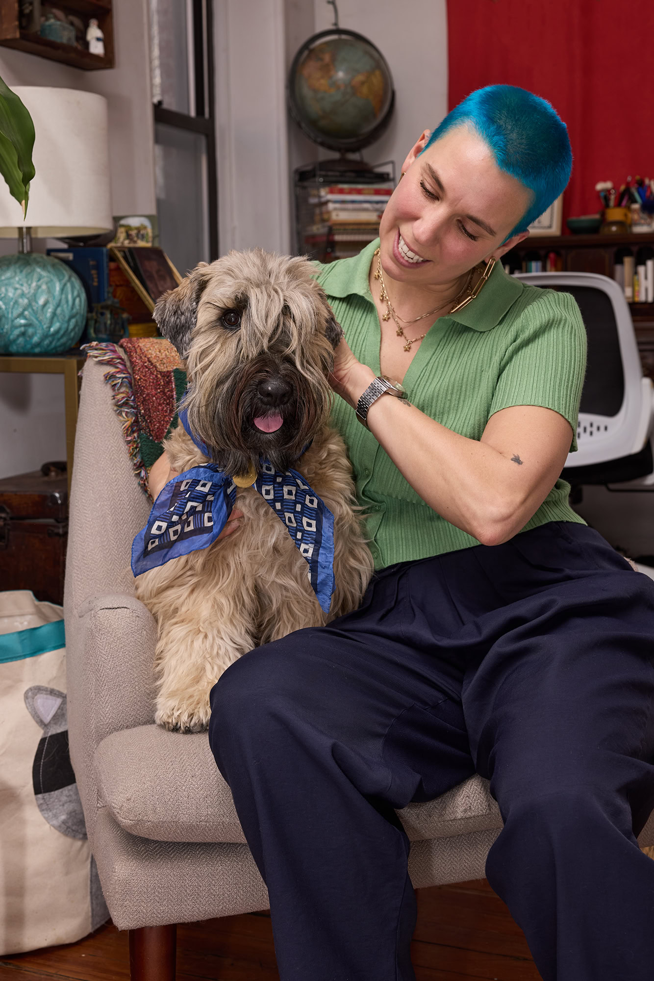 blue haired woman pets a dog in a living room