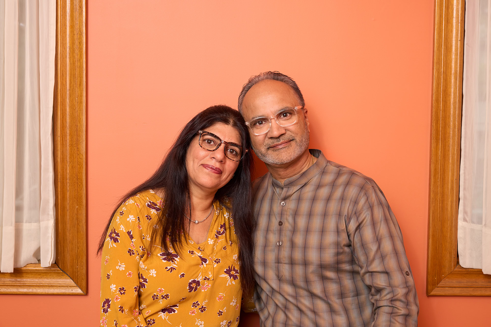 middle age couple wearing glasses inside a home