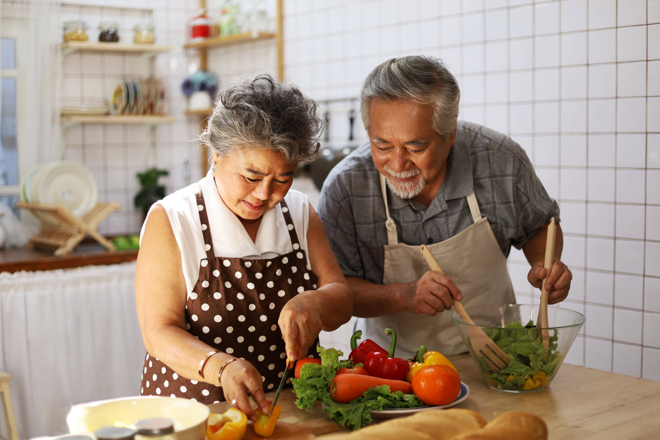 A happy senior couple preparing a healthy meal at home with items purchased with their MetroPlusHealth Flex Rewards Card.
