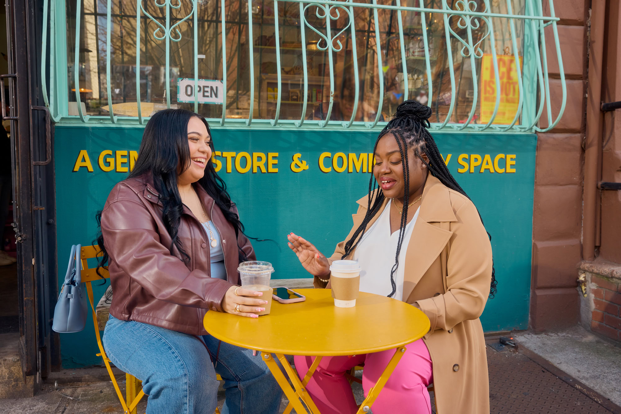 Young professional using a laptop in a café, researching MetroPlusHealth Explore Plan options for health coverage.
