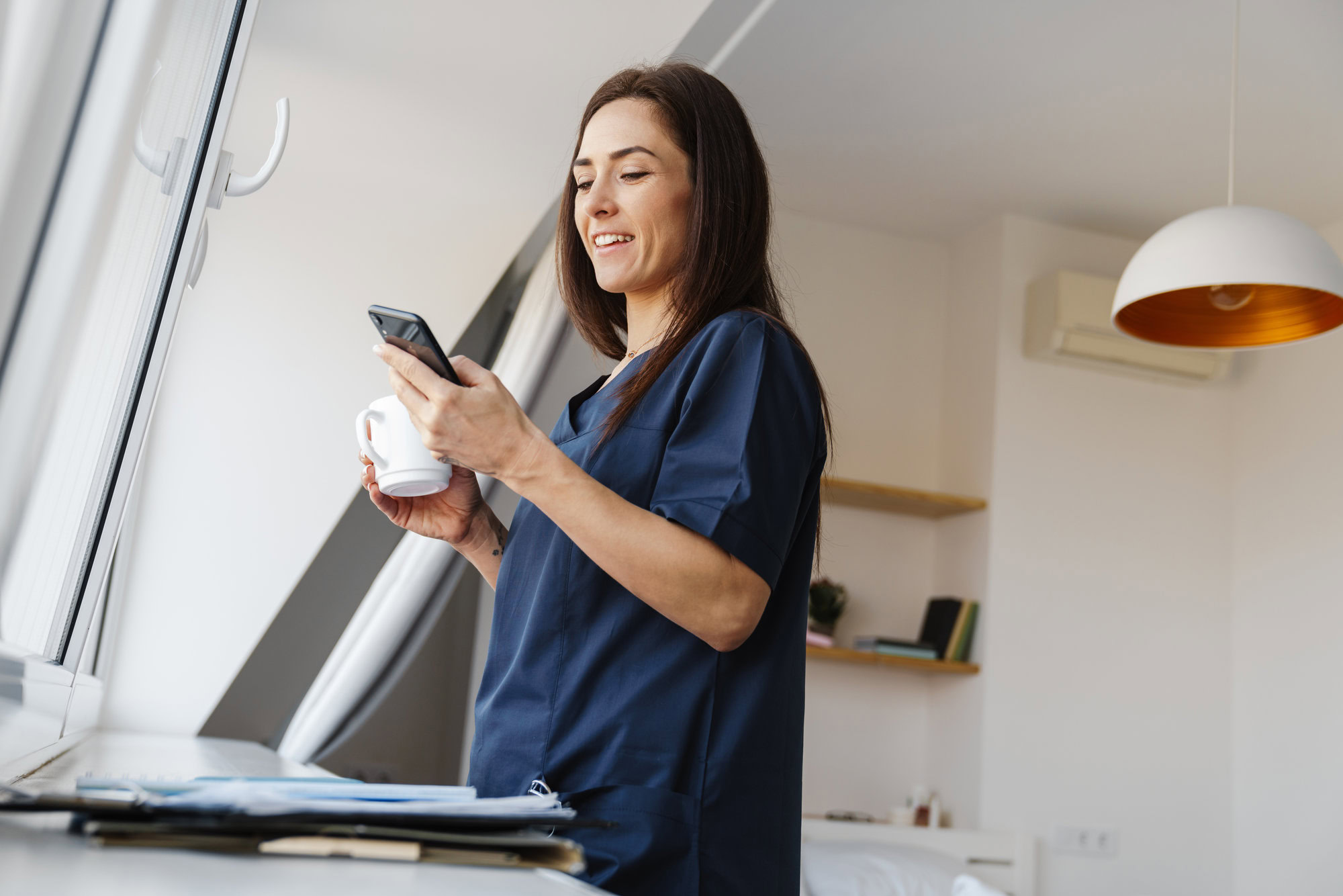 Doctor filling out MetroPlusHealth Provider Initial Application form at a desk with medical documents and a laptop. Doctor filling out MetroPlusHealth Provider Initial Application form at a desk with medical documents and a laptop.